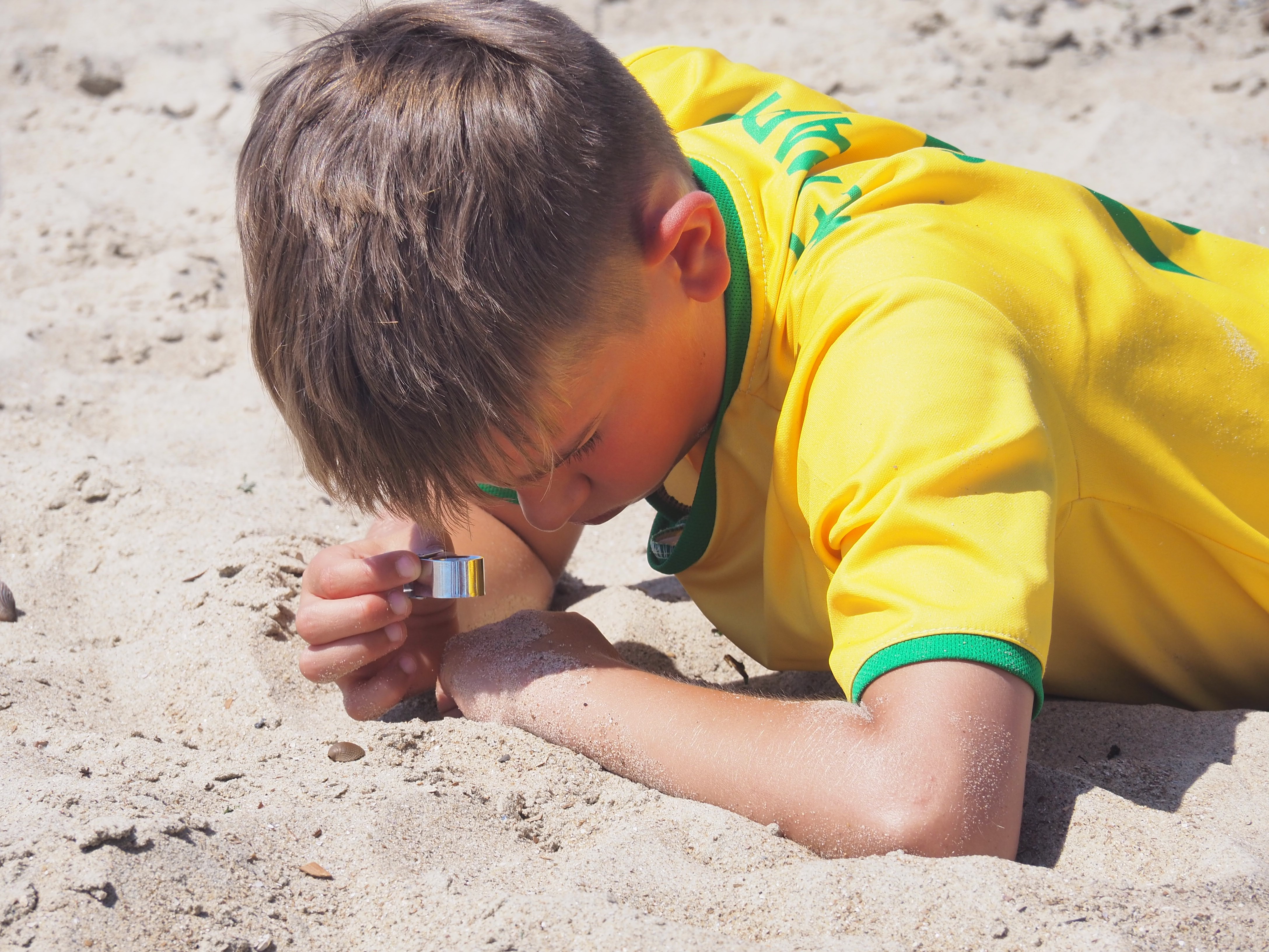 Zandkorrels bewonderen op het strand